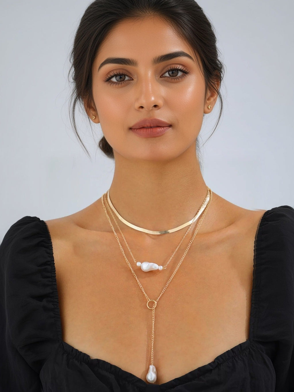 Three-layer gold and pearl necklace worn on model